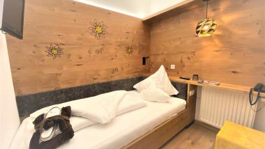 Einzelzimmer im Naturhotel Die Waldruhe mit Holzwand und Sonnenblumendekor