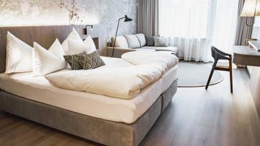 Krumers Alpin hotel room with beds, sofa, and desk in modern style