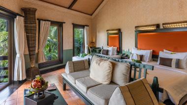 Room with double bed and sofa at The Mangosteen Ayurveda & Wellness Resort