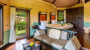 Spacious room with bed and sitting area at The Mangosteen Ayurveda & Wellness Resort