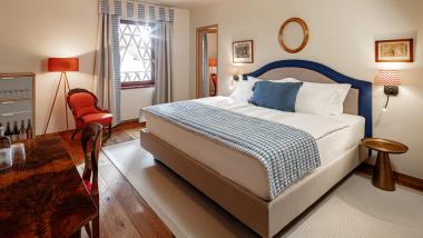 Gemütliches Schlafzimmer im Castel Sallegg mit Holzfußboden und rotem Sessel