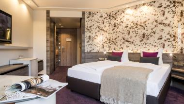 Modernes Doppelzimmer im Land & Golf Hotel Stromberg mit dekorativer Wand und Fernseher
