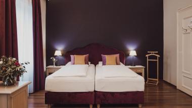 Double room at Hotel Adria with purple beds and cozy decor