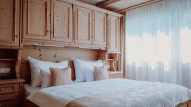 Gemütliches Schlafzimmer mit Holzvertäfelung im Das Verwall Lech Hotel