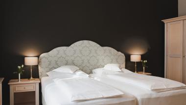 Double room at Hotel Adria with two beds and bedside tables with lamps