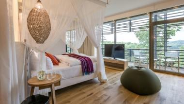Helles Hotelzimmer mit Holzboden und Balkon im Seezeitlodge Hotel & Spa
