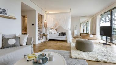 Helle Suite im Seezeitlodge Hotel & Spa mit gemütlichem Bett und Sitzbereich