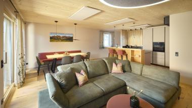 Wohnzimmer mit grünem Ecksofa und Essbereich im Hochfeldhof