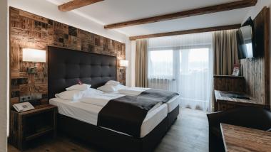 DER GREIL Hotelzimmer mit Doppelbett, Stühlen und Tisch in modernem Design