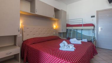 Camera da letto con coperte rosse a fiori e mobili moderni