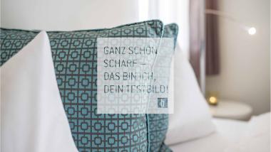 Dekorative Kissen auf einem Bett mit modernem geometrischem Muster.