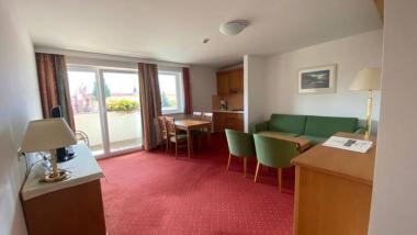 Hotel Moarhof Zimmer mit grünem Sofa, Essbereich und Balkon