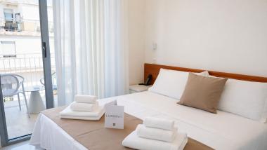 Camera accogliente al Regal Hotel Rimini con balcone e asciugamani bianchi