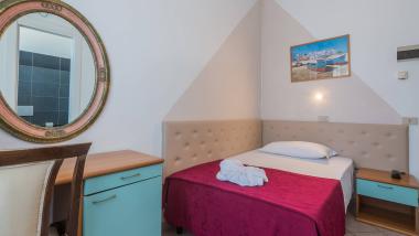 Piccola camera con copriletto rosso e fiori fatti con asciugamani