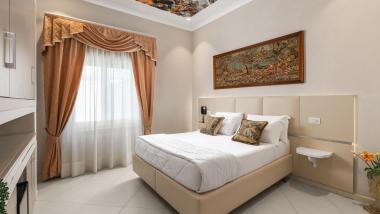Camera dell'Hotel Regina Caserta con letto matrimoniale, quadro e tende