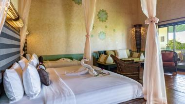 Relaxing room at The Mangosteen Ayurveda & Wellness Resort with draped curtains and cozy seating