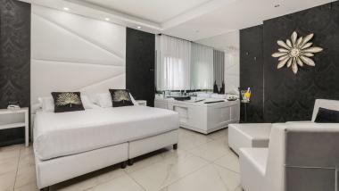 Camera elegante con letto bianco al Reggia Suite Spa Hotel
