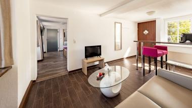 Gemütlicher Wohnbereich im Burghotel Staufeneck mit TV und moderner Einrichtung