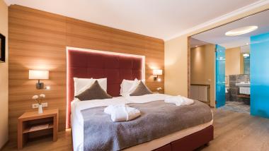 Modernes Hotelzimmer im Hotel Mignon Meran Park & Spa mit Doppelbett und Bad