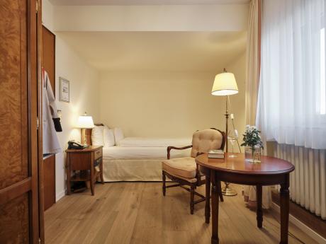 Hotel Reppert: gemütliches Zimmer mit Bett, Sesseln und rundem Holztisch