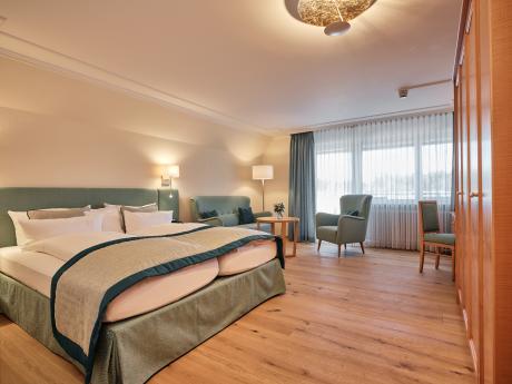 Hotel Reppert elegantes Doppelzimmer mit Bett, Sesseln und großen Fenstern