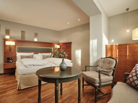 Hotel Reppert: Elegantes Hotelzimmer mit Doppelbett, Sesseln und rundem Tisch