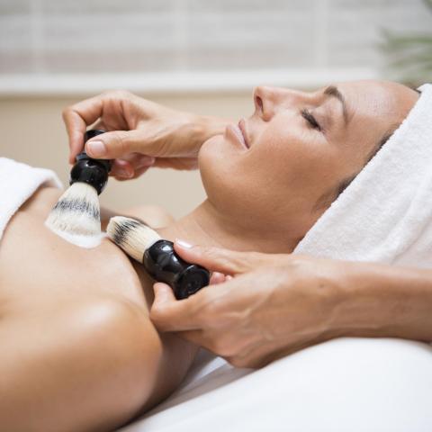 Brandnamic Spa-Gesichtsbehandlung mit Pinseln bei entspannter Frau