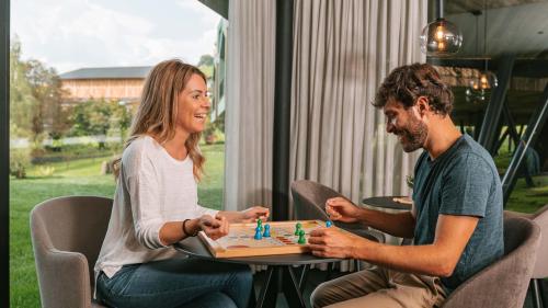 Paar spielt Brettspiel im Parc Hotel Florian mit Blick ins Grüne