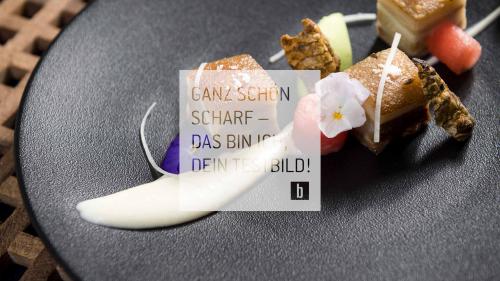 Piatto gourmet servito su un piatto nero con presentazione creativa.