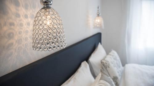 Stilvolles Schlafzimmer mit Pendelleuchten und dekorativen Kissen.