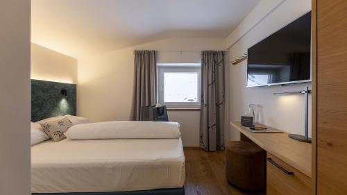 Camera moderna all'Unterrain Lifestyle Hotel con letto, scrivania e TV