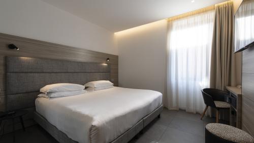 Modern double room at Hotel Touring Verona with large bed and desk
