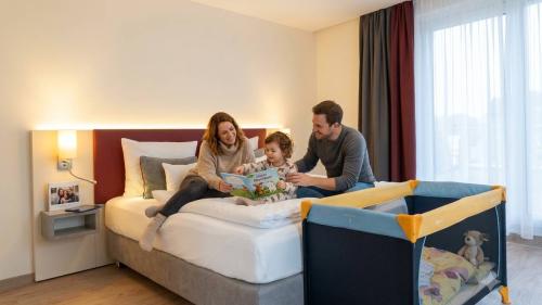 Familie liest auf dem Bett im Mythenresort Heimdall, Kinderreisebett nebenan