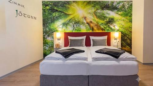 Gemütliches Doppelbett im Zimmer Jötunn im Mythenresort Heimdall mit Waldwandbild