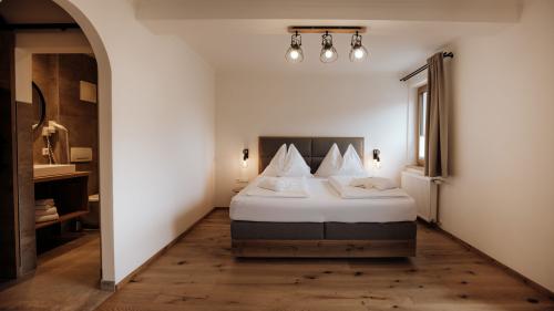 Schlafzimmer im Hotel Forstauerwirt mit Doppelbett und Holzboden