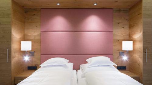 Hotel Panorama: Doppelzimmer mit zwei Betten, Holzverkleidung und rosafarbenem Kopfteil