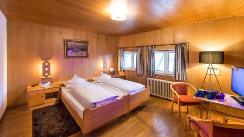 Gemütliches Zimmer im Parc Hotel Florian mit Holzwänden und Doppelbett