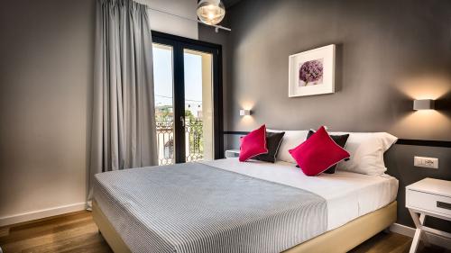 Teku Boutique Hotel: camera matrimoniale moderna con balcone, letto bianco e cuscini rossi