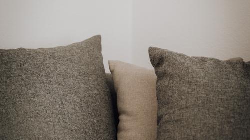Graue und beige Kissen auf einem Sofa im Hotel Forstauerwirt