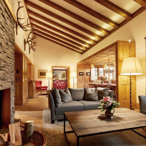 Hotel Post Lech: Gemütliche Lounge mit Kamin, Sofas und Holzbalkendecke