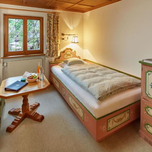 Einzelzimmer mit Bett und Sitzecke im Hotel Post Lech