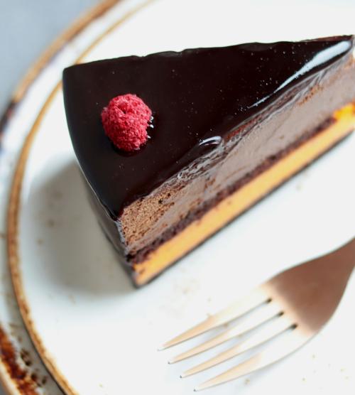 Schokoladenkuchenstück mit Himbeere auf Teller im Resort La Ginabelle Zermatt