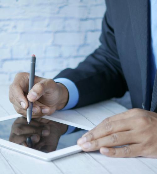 Person in Anzug benutzt Tablet mit Stift im Resort La Ginabelle Zermatt