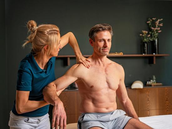 Physioterapeutin behandelt Mann