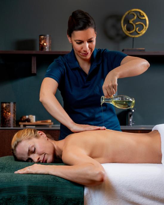 Eine Frau bekommet eine Abhyanga MAssage mit Ölguss
