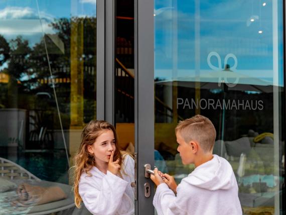 Enfants ouvrant la porte du Panoramahaus au Pfalzblick Wald Spa Resort