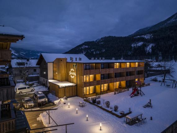 Der Dolomitenhof ***S im winterlichen Abendlicht, umgeben von verschneiten Bergen