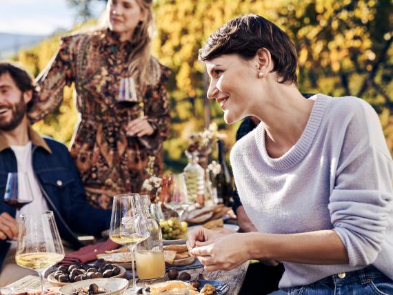 Gäste genießen Wein und Snacks im Hotel Waldsee im Freien