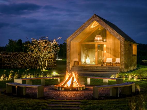 Seezeitlodge Hotel & Spa Außenansicht mit Feuerstelle und gemütlichem Beleuchtung abends