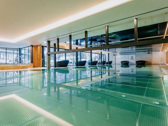 Innenpool im Familienresort Buchau mit Sitzbereich und Glasfassade
